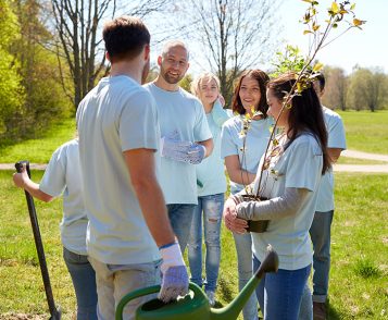 group-of-volunteers-with-tree-seedlings-in-park-PE9NTNA.jpg